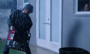 Guy carrying a portable generator in the rain